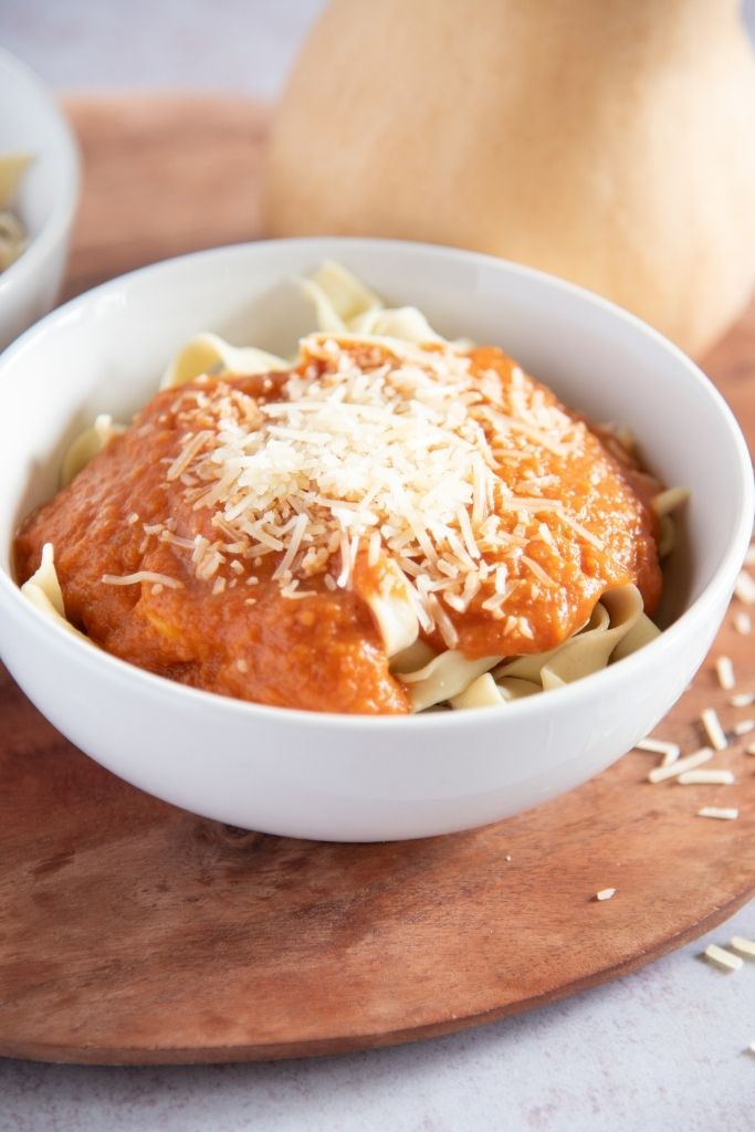 a close up of a bowl of noodles with butternut squash pasta sauce on top