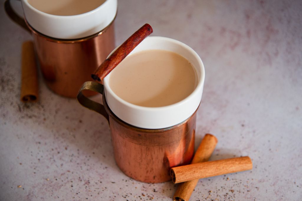 a cups of bourbon chia with cinnamon stick next to them