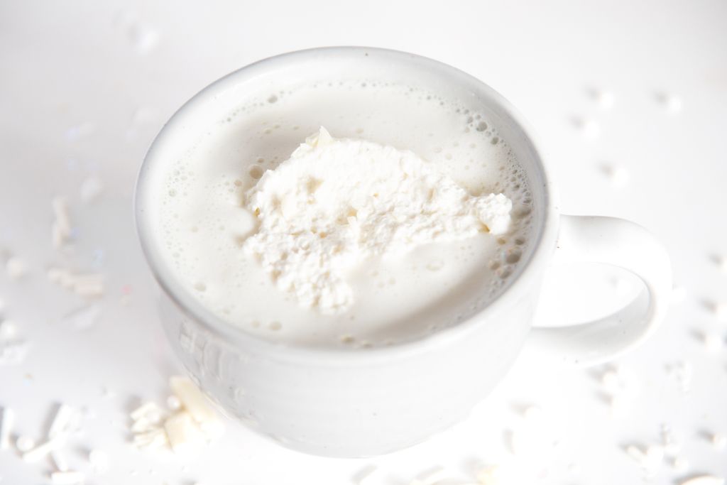 a cup of white hot chocolate with whipped cream on top 