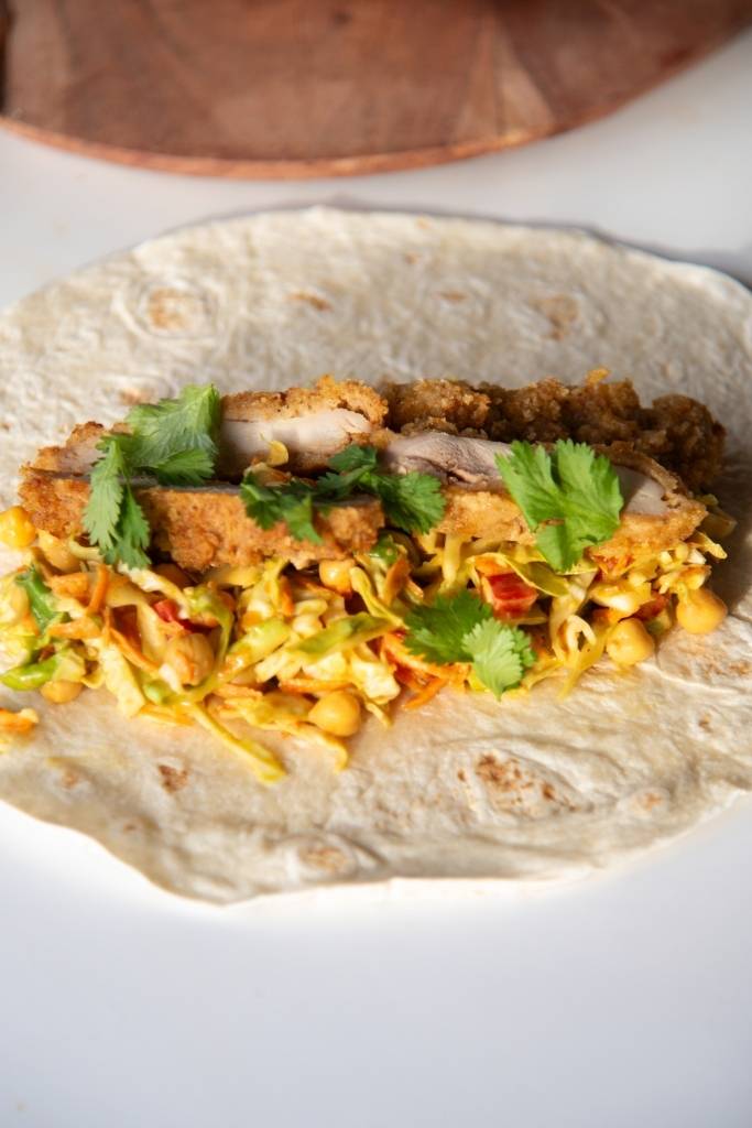 a close up of a wrap that hasn't been rolled up yet, you can also see part of a wooden plate behind it