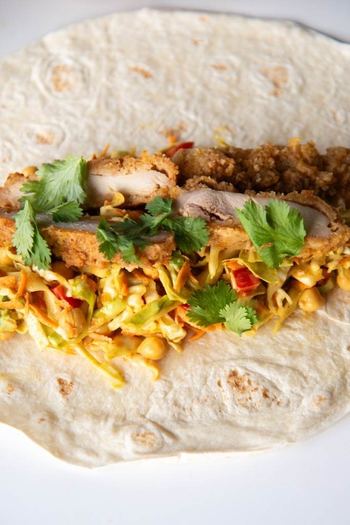 a close up of a tortilla with wrap filling on it