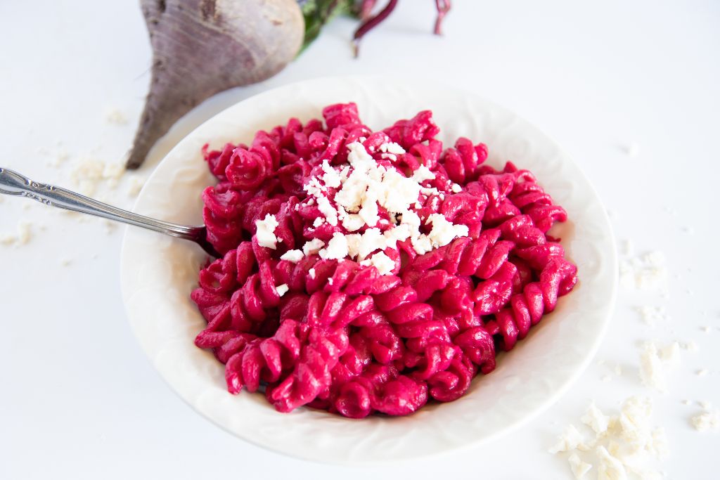 a bowl of sauce covered noodles with a fork stuck in them. 