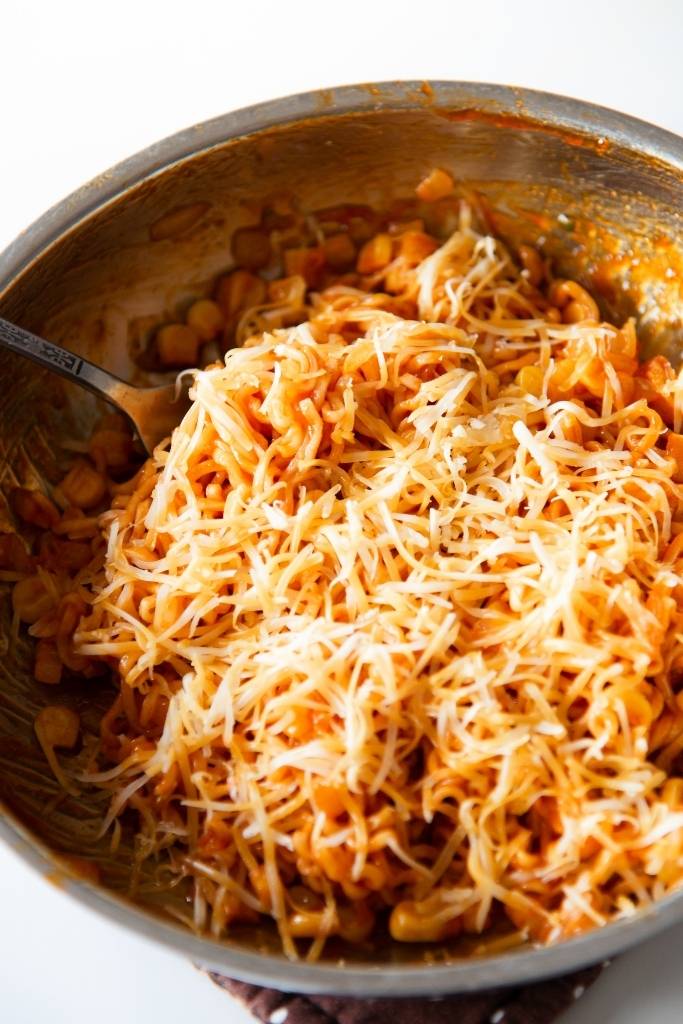 a close up of cheese covered noodles with a fork stuck in them