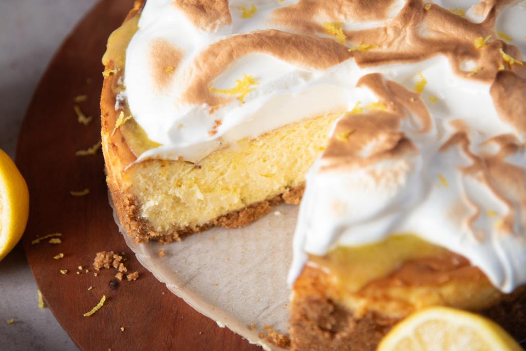a lemon meringue cheesecake with a slice taken out of it