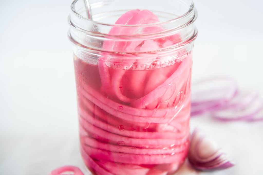 a close up of a jar of pickled red onions