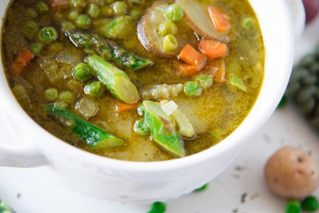 a cut off picture of a bowl of soup with fresh veggies next to it 