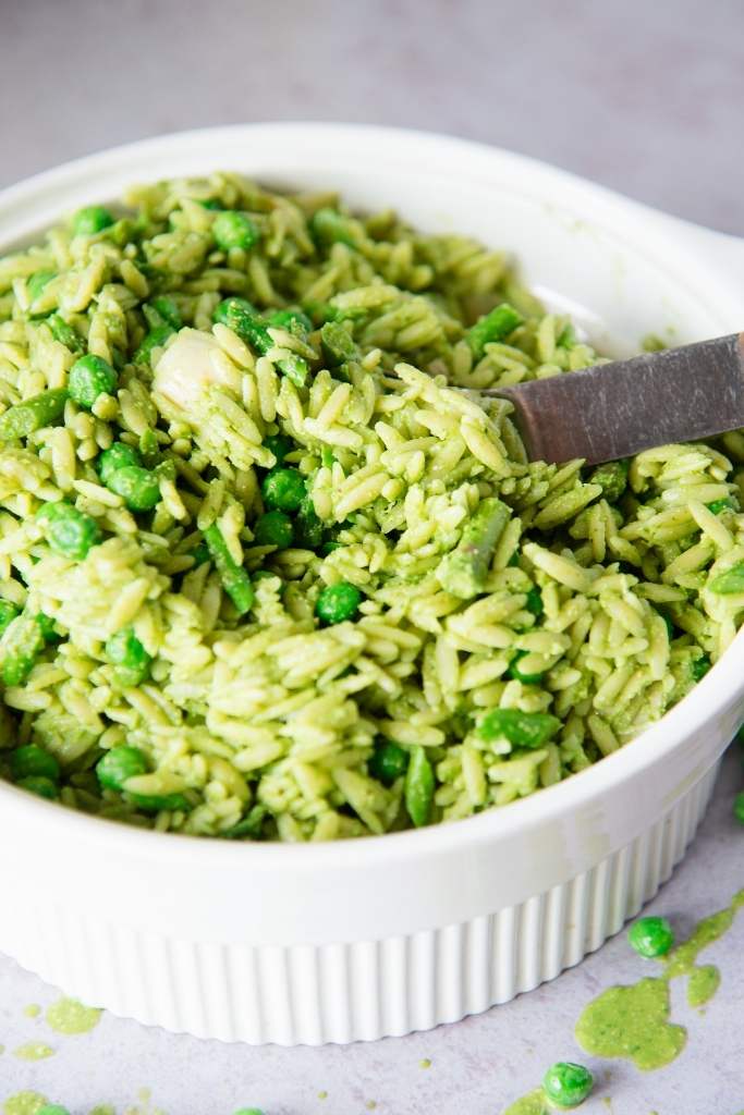 a close-up of a bowl of pasta salad with a spoon in it 