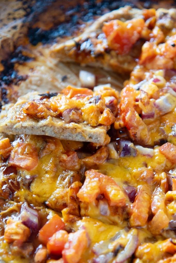 a close up of a piece of pizza that is sitting on the rest of the pizza 