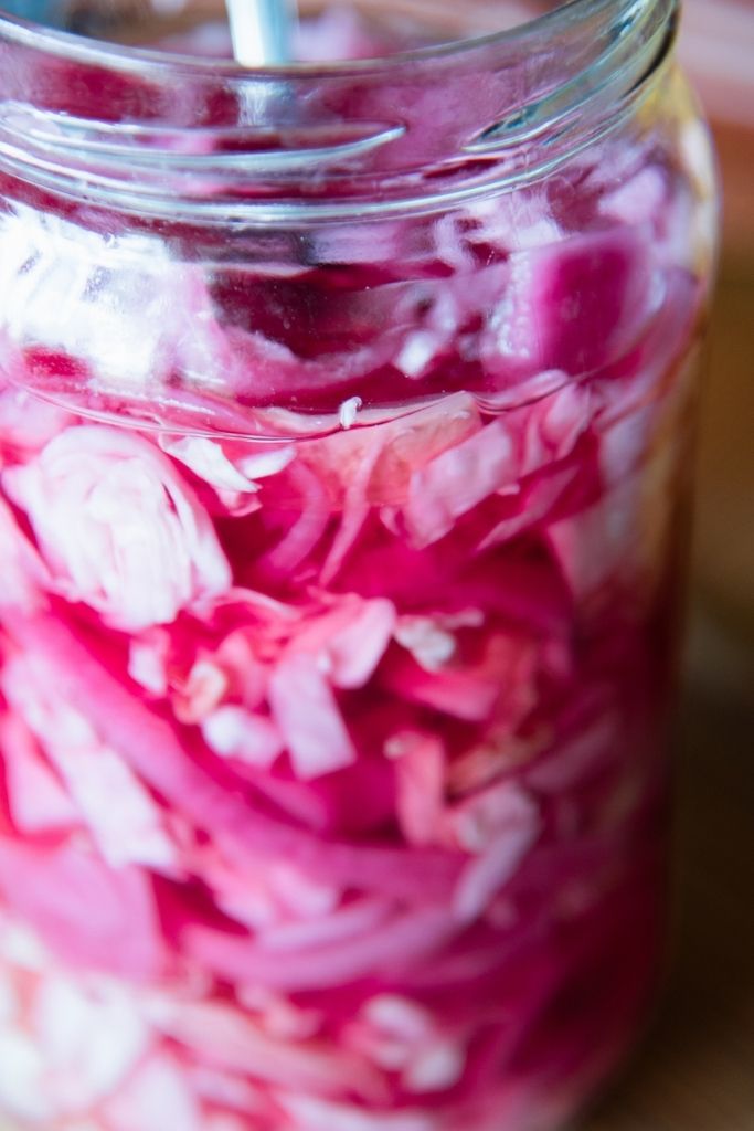 a close up of a jar of pickled cabbage and onions