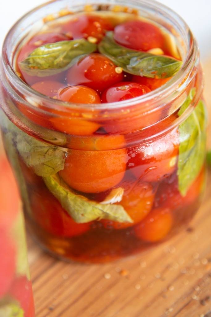 a close up of a jar of pickled tomatoes 