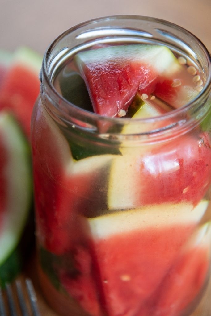 a close up of a slice of pickled watermelon in a jar 