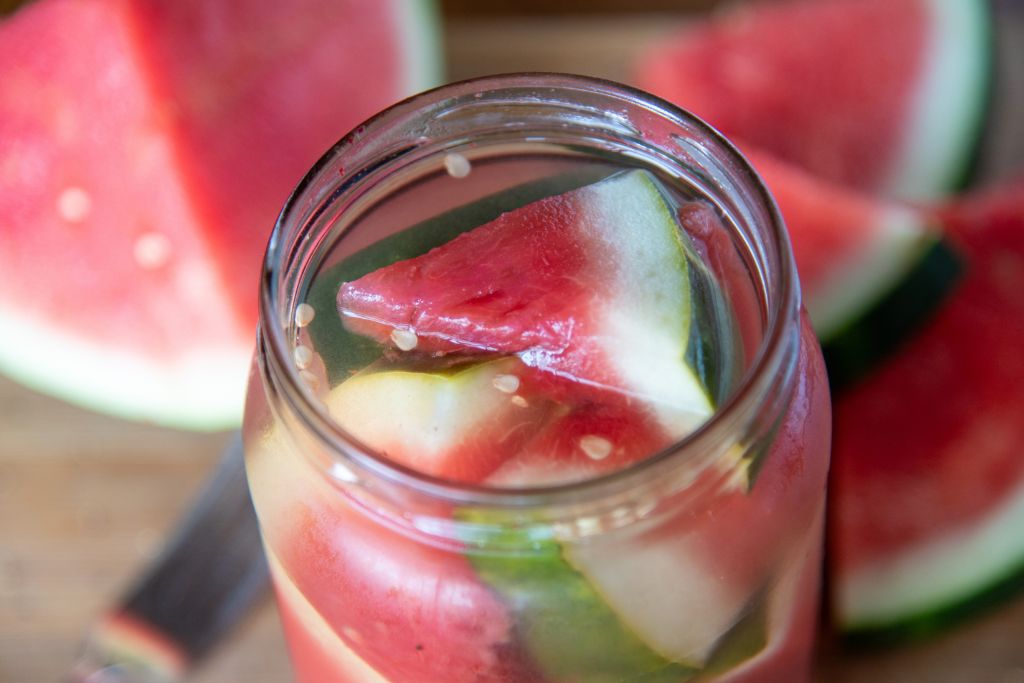 a close up of an open jar of pickled watermelon