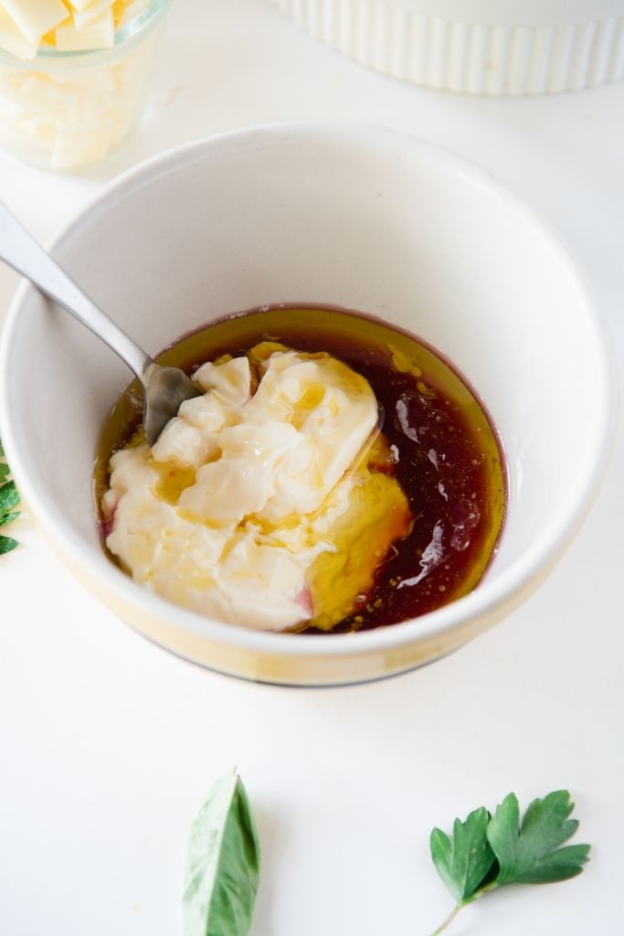 a bowl of salad dressing with a spoon in it 