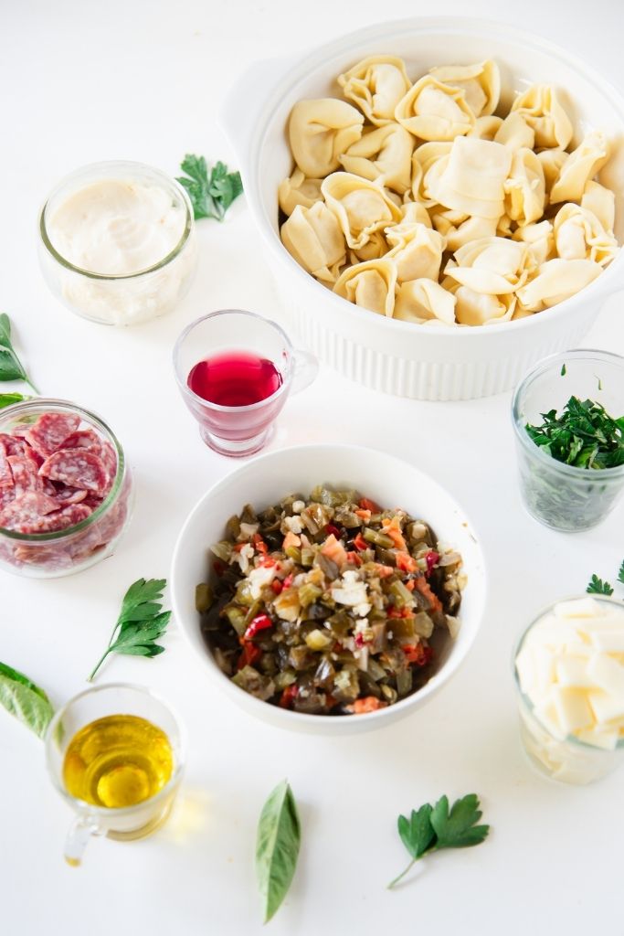 all of the pasta salad ingredients set out on a table 