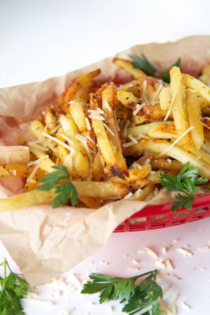a close up cut off picture of a basket of fries