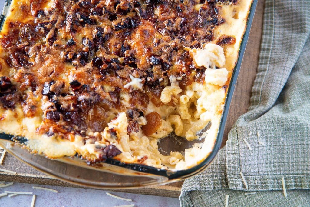 a pan of mac n cheese that has a scoop taken out of it