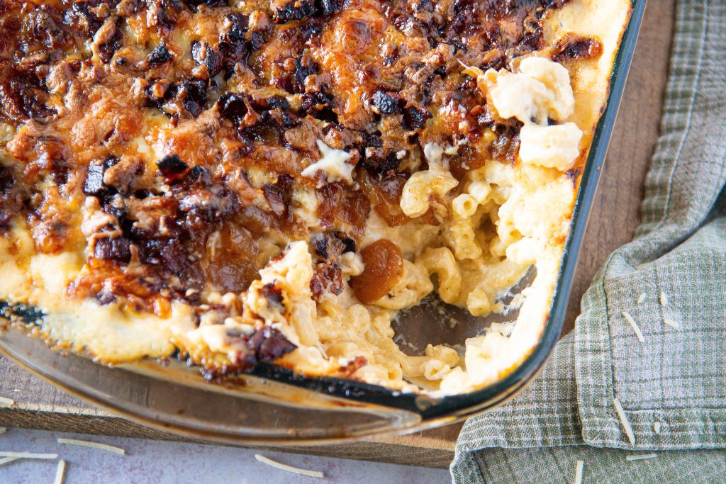 a close up of a pan of mac n cheese that has a scoop taken out of it