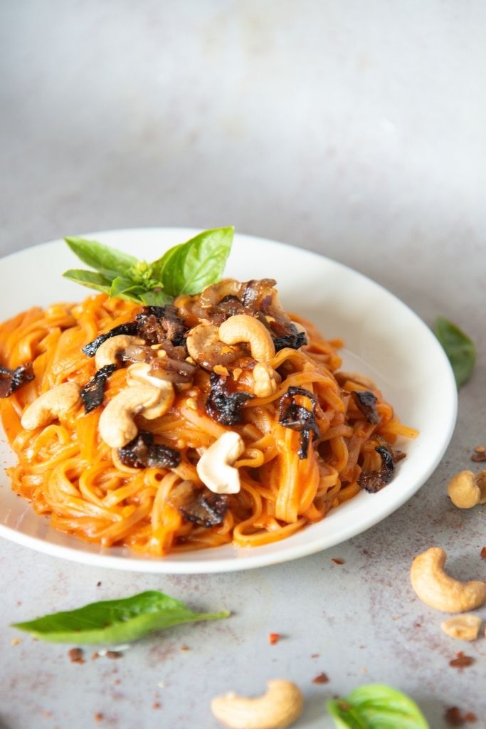 a cutoff picture of a plate of red curry noodles 