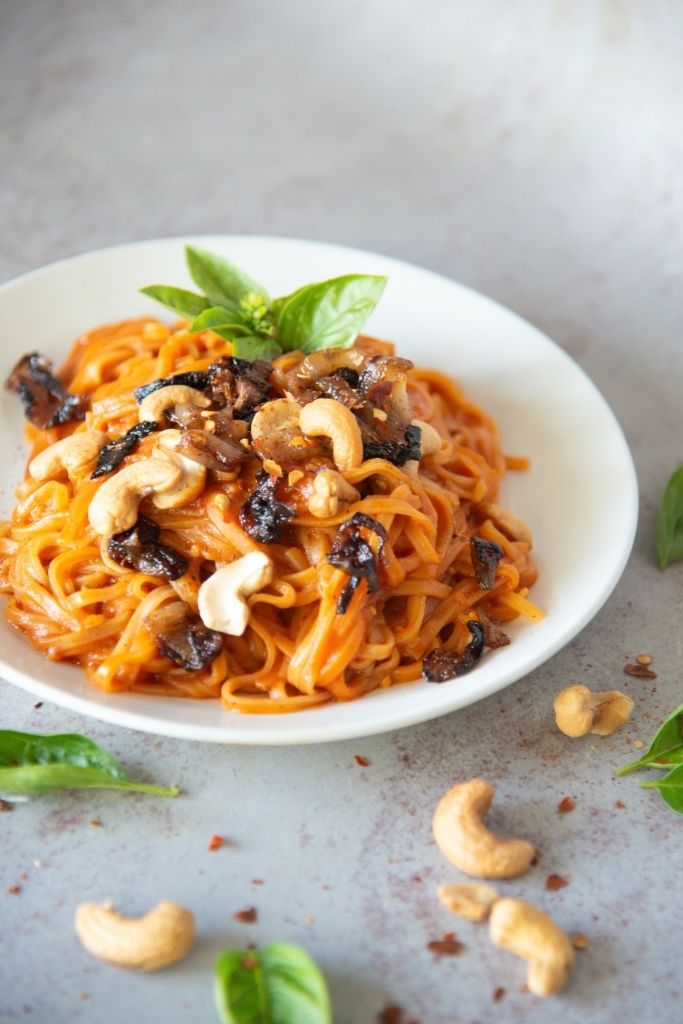 a close up of a plate of red curry noodles 